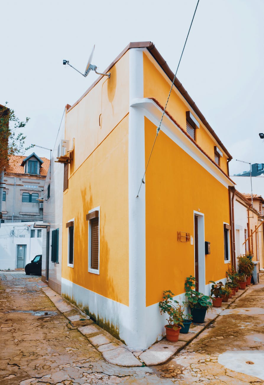 yellow and white concrete roadside house
